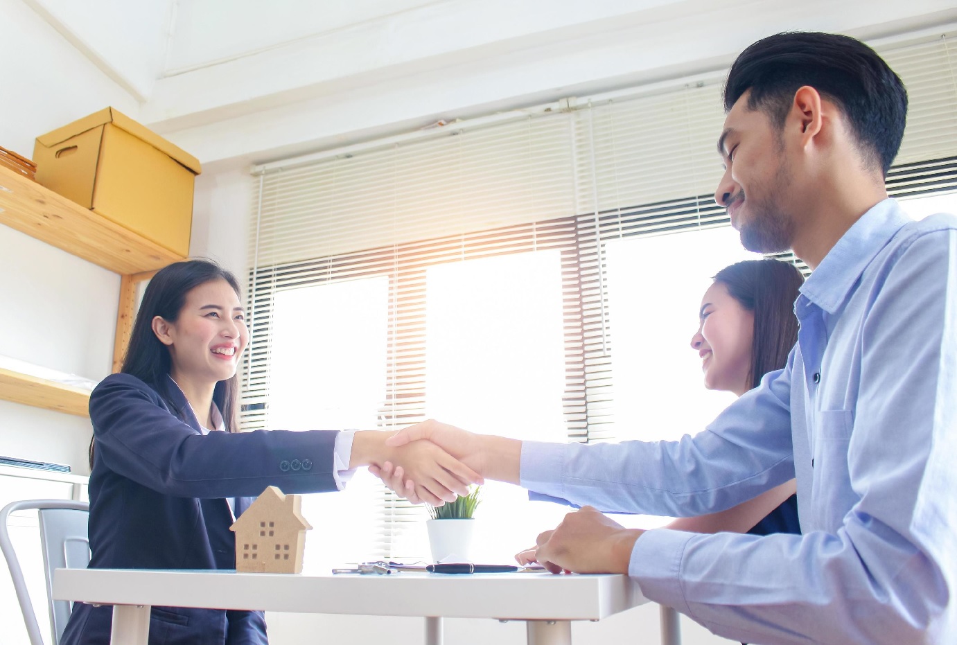 Businesswoman and customers shake hands